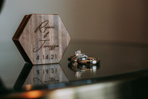 Wedding Ring Shot | Carved Wood Ring Box with Couples Names and Wedding Date | Square Ascher Cut Diamond Solitaire Engagement Ring with Channel Set Diamond Band and Platinum Men Wedding Ring Band