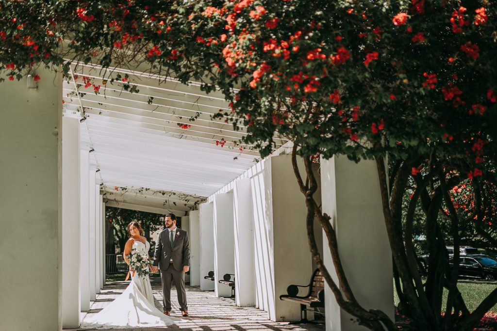 Outdoor Bride and Groom Portrait in Vinoy Park Downtown St. Pete Florida | Groom Wearing Classic Charcoal Grey Suit with Green Tie | Lace Fit and Flare Mermaid Spaghetti Strap Wedding Dress Bridal Gown with Scallop Edge Lace Train Hem