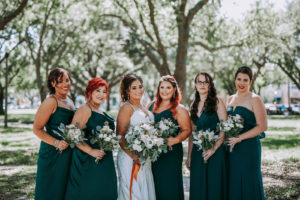 Bride and Bridesmaids Outdoor Portrait | Bridesmaids Wearing Deep Green Long Gown Dresses | Natural Rustic Wedding Bouquets with White Roses, Scabiosa Pods and Eucalyptus Greenery
