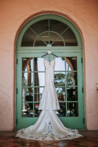 Wedding Dress Hanger Shot on Colorful Green Glass Doorway Arch | Lace Fit and Flare Mermaid Spaghetti Strap Wedding Dress Bridal Gown with Scallop Edge Lace Train Hem