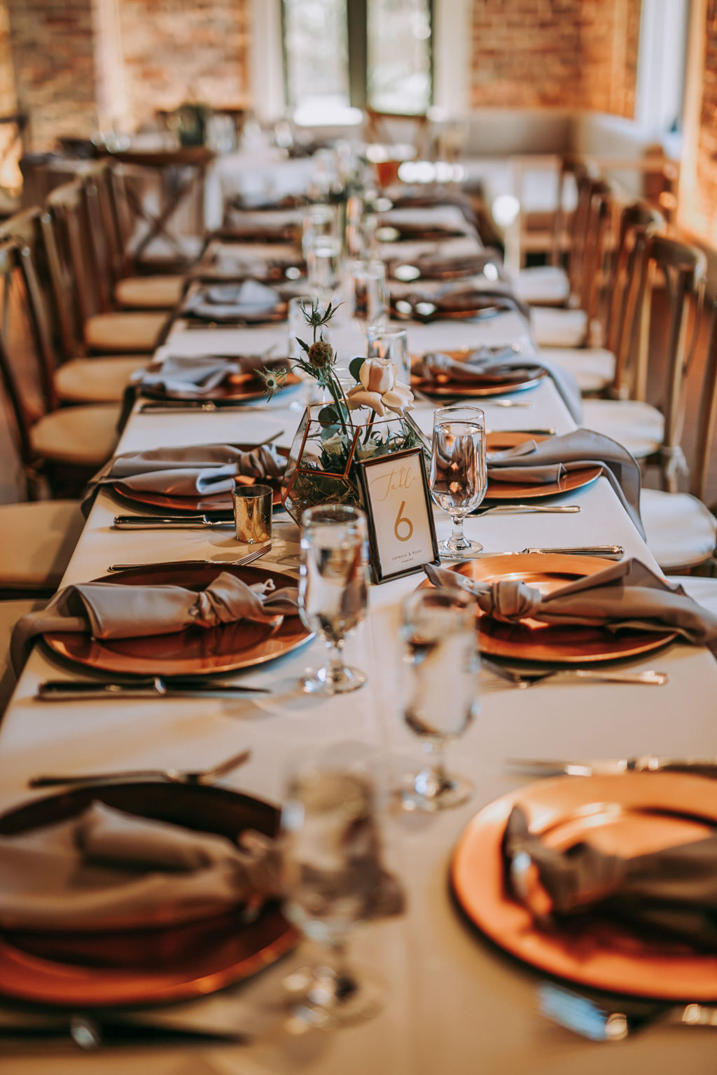 Long Feasting Tables with White Linens and Copper Charger Plates with Taupe Napkins for Wedding Reception | Perfecting the Plan