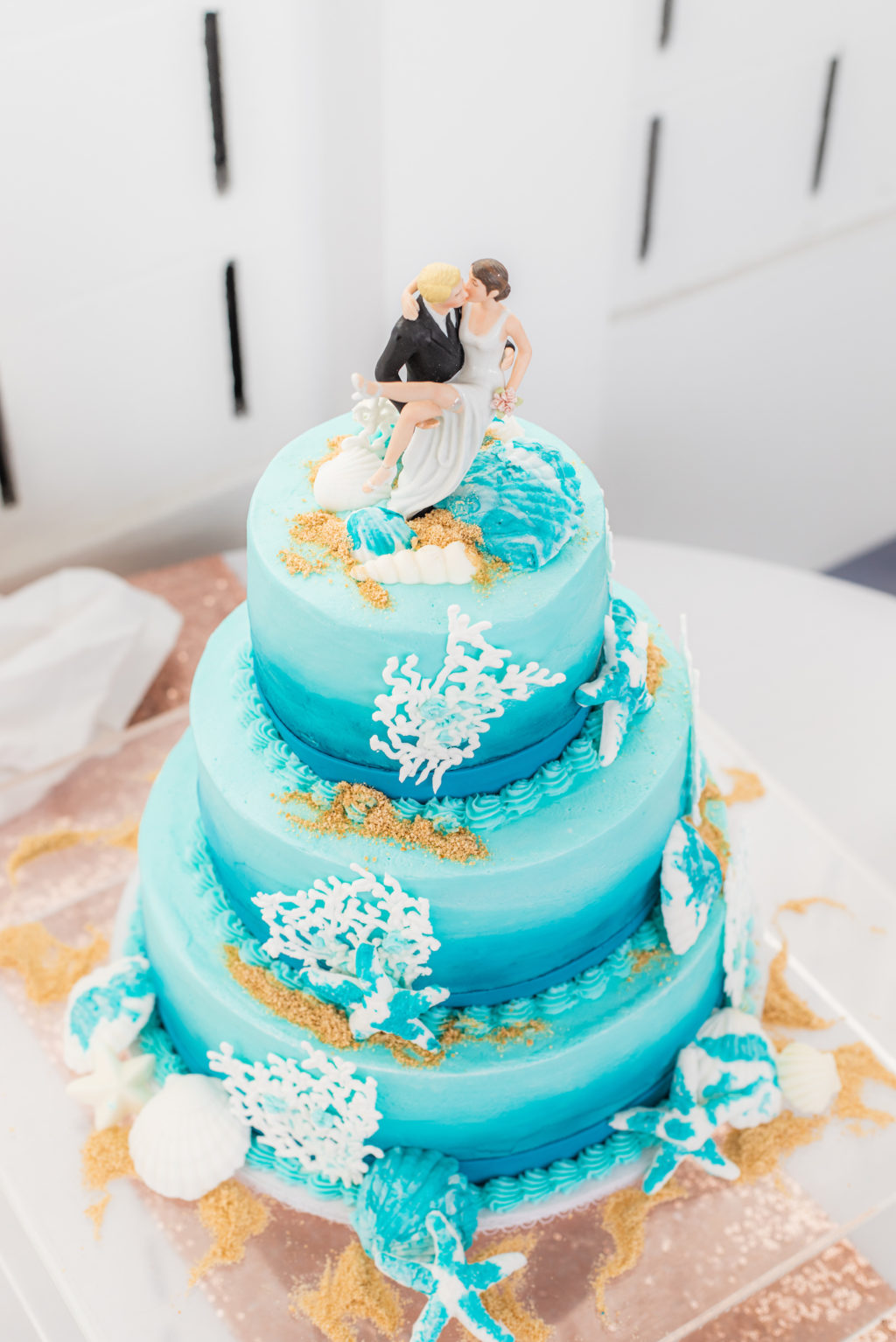 Tropical Ocean Theme Blue Three Tier Wedding Cake with Fondant Seashells and Coral, Bride and Groom Figurine Cake Toppers