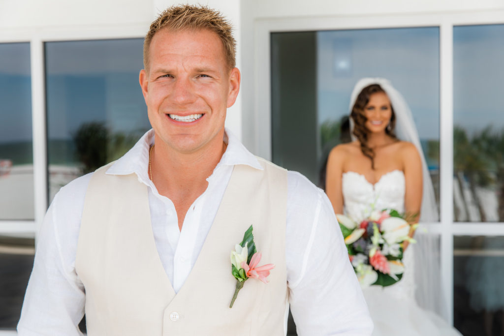 Tampa Groom Happy Reaction Waiting for Bride During First Look Wearing Tan Vest, White Button Down Shirt, Tropical Boutoniere and Back Against Bride First Look Photo
