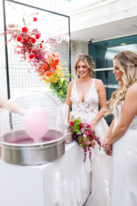 Modern Gay LGBTQ+ Pride Wedding, Lesbian Brides, Pink Cotton Candy Machine, Rectangle Black Metal Grid Mesh Arch with Colorful Rainbow Red, Pink, Orange, Yellow and Green Floral Arrangement with Neon Pink Sign | Tampa Bay Wedding Planner Stephany Perry Events | Rooftop Wedding Venue Hotel Alba Tampa