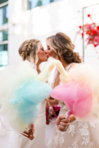 Modern Gay LGBTQ+ Pride Wedding, Lesbian Brides Kissing Holding Pink and Blue Cotton Candy | Tampa Bay Wedding Planner Stephany Perry Events
