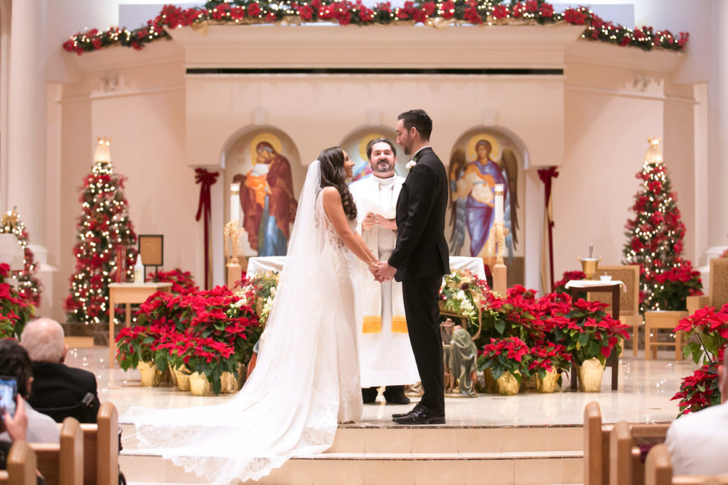 Traditional Bride and Groom Exchanging Wedding Vows Christmas Ceremony at Altar of Wedding Venue St. Raphael Catholic Church | Tampa Bay Wedding Photographer Carrie Wildes Photography