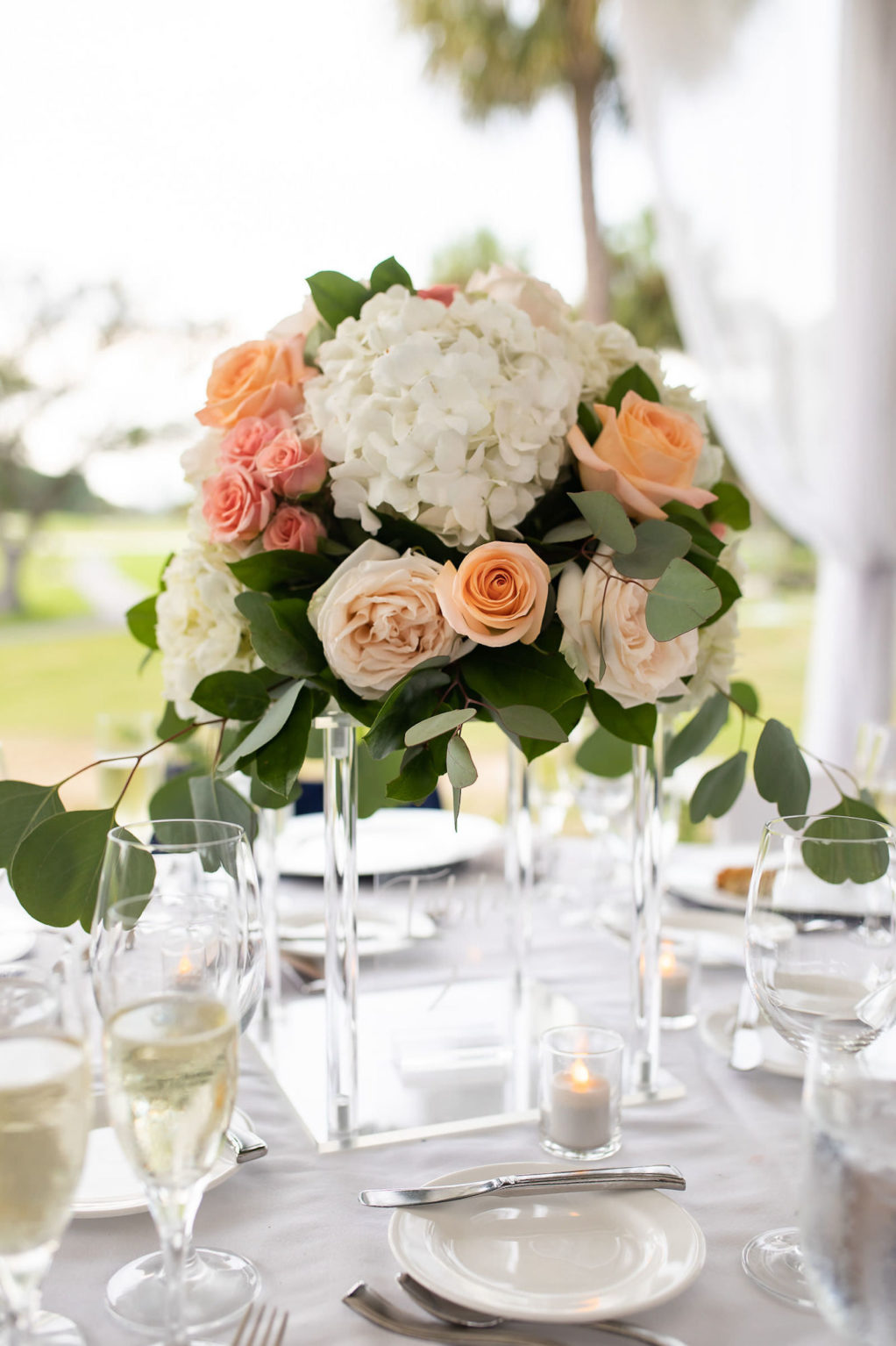 Acrylic Wedding Centerpiece Riser Vase with Peach and Coral Roses, White Hydrangea and Eucalyptus Greenery
