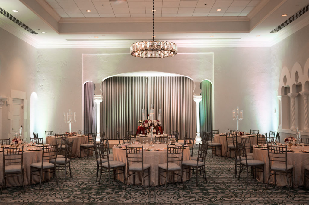 Elegant Ballroom Wedding Reception Decor, Gold Chargers, Pink Uplighting, Tall Glass Candle Centerpieces with Burgundy and White Floral Arrangement | Tampa Bay Wedding Photographer Carrie Wildes Photography | St. Pete Wedding Venue Vinoy Renaissance