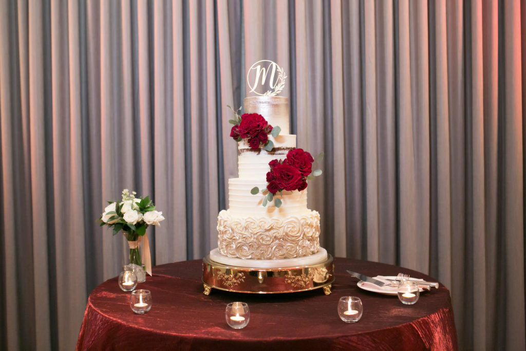 Elegant Four Tier with Piped Buttercream Roses, Textured Buttercream, Semi Naked and Silver Painted Wedding Cake, Laser Cute Monogram Cake Topper, Burgundy Red Roses on Gold Cake Stand and Burgundy Red Table Linen | Tampa Bay Wedding Photographer Carrie Wildes Photography | St. Pete Wedding Baker The Artistic Whisk