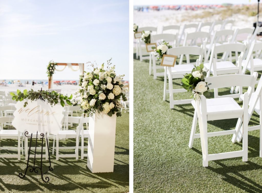 Waterfront Lawn Timeless Elegant Wedding Ceremony Decor, White Folding Chairs, Acrylic White and Gold Welcome Sign with White Roses, Greenery Floral Arrangement | Tampa Bay Wedding Photographer Lifelong Photography Studio | Clearwater Beach Wedding Venue Sandpearl Resort | Wedding Planner Blue Skies Weddings and Events | Wedding Florist Iza's Flowers