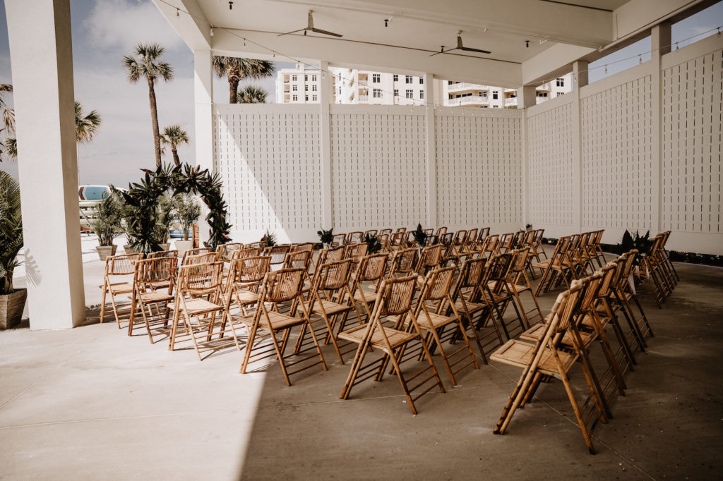 Tropical Elegant Waterfront Wedding Ceremony Decor, Bamboo Chairs, Circular Palm Fronds and Leaves Wedding Arch | Wedding Venue Hilton Clearwater Beach | Tampa Bay Wedding Florist Iza's Flowers