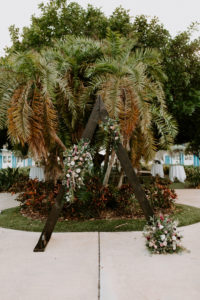 Tropical Boho Garden Wedding Ceremony Decor, Triangular Wooden Arch with Lush Floral Arrangements | St. Pete Wedding Venue Postcard Inn on the Beach