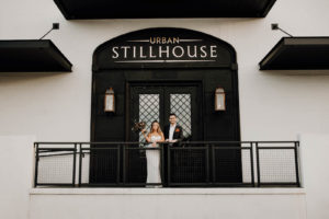 Tampa Bride and Groom Standing Outside on Balcony of Wedding Venue Urban Stillhouse St. Pete