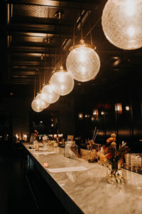 Dark and Moody Wedding Reception Decor, Globe Modern Chandeliers, Long Marble Table with Floral Centerpieces | Wedding Venue Urban Stillhouse St. Pete