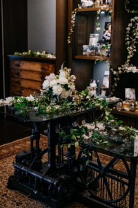Vintage Inspired Florida Wedding Reception Decor, Greenery with Ivy and Vines Wrapped Around Black Metal Industrial Furniture, Delicate Floral Centerpieces with Blush Pink Peonies, White Roses and White Hydrangeas, Decorated with Family Photos | Tampa Bay Wedding Venue J.C. Newman Cigar Co. in Ybor City