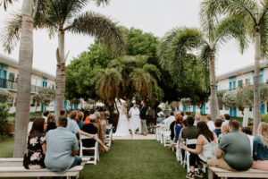 Tropical Garden Bride and Groom Exchanging Wedding Vows During Outdoor Wedding Ceremony | St. Pete Wedding Venue Postcard Inn