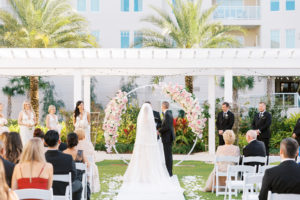 Bride and Groom During Elegant Outdoor Clearwater Lawn Wedding Ceremony Belleview Inn, Garden Inspired Decor with Large Floral Circle Arch Under Pergola, with Pink Cherry Blossoms, Ivory Roses, Blush Peonies, and White Hydrangeas | Florida Luxury Wedding Planner Parties A'La Carte | Tampa Bay Wedding Florist Bruce Wayne Florals