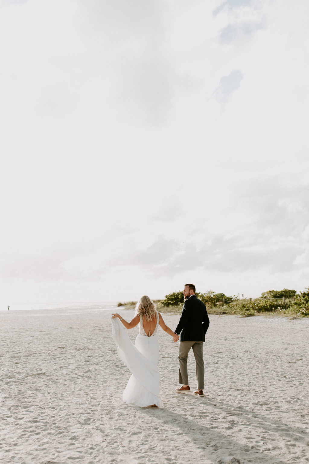 Florida Bride and Groom Walking on the Sandy Beaches | St. Pete Wedding Venue Postcard Inn on the Beach