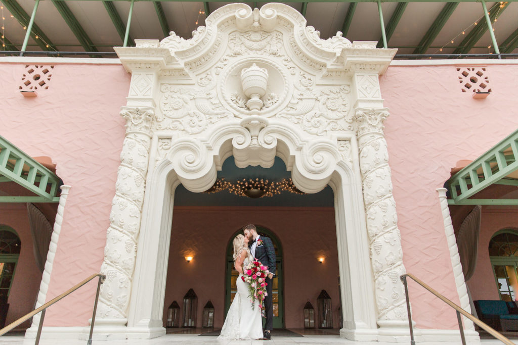 Elegant Tampa Bride and Groom Kissing Under White Unique Arch at St. Pete Wedding Venue The Vinoy Renaissance