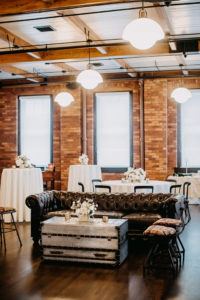 Vintage Inspired Florida Wedding Cocktail and Reception Decor, Rented Antique Seating Furniture with Trunk, Hightop Tables with Low Floral Centerpieces, | Ybor Wedding Venue J.C. Newman Cigar Co.