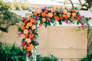 Outdoor Garden Wedding Ceremony Decor, White Pergola with Lush Floral Arrangement, Orange Roses, Pink and Purple Flowers with Greenery | Tampa Bay Wedding Florist Monarch Events and Design