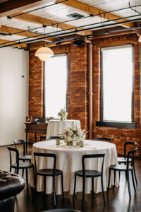 Vintage Inspired Florida Wedding Reception Decor, Exposed Brick Venue with Round Tables, White Linens, Low Floral Centerpieces, Blush Pink Peonies, Ivory Roses | Ybor Wedding Venue J.C. Newman Cigar Co.
