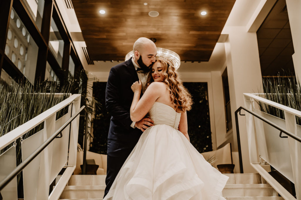 Florida Bride and Groom Dark and Moody Wedding Portrait on Staircase of Waterfront Wedding Venue Hilton Clearwater Beach