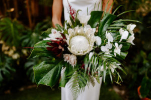 Tropical Inspired Florida Bridal Bouquet, White King Protea with Red Florals and Orchids, Monstera Leafs, Palm Greenery, Jungle Inspired Wedding | Tampa Bay Wedding Planner Parties A'La Carte