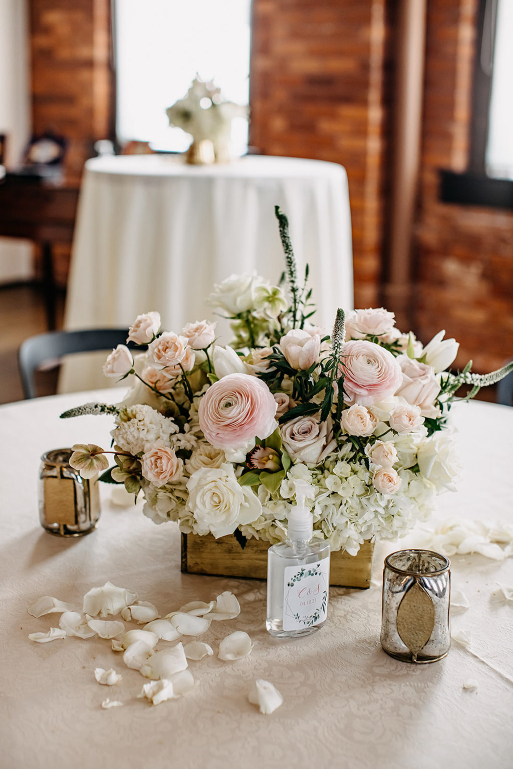 Vintage Inspired Florida Wedding Reception Decor, Exposed Brick Venue with Round Tables, White Linens, Low Floral Centerpieces, Blush Pink Peonies, Ivory Roses, Hydrangeas, Carnations, Wooden Flower Box, Two Tone Mercury Candle Votives, COVID 19 Safe Custom Hand Sanitizer, | Ybor Wedding Venue J.C. Newman Cigar Co.