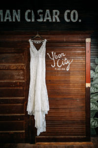 Tampa Bay Vintage Inspired Lace Wedding Dress Hanging In Industrial Wedding Venue | J.C. Newman Cigar Co. in Ybor City Florida