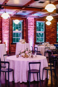 Vintage Inspired Florida Wedding Reception Decor, Exposed Brick Venue with Round Tables, White Linens, Low Floral Centerpieces, Blush Pink Peonies, Ivory Roses, Hydrangeas, Carnations, Wooden Flower Box, Two Tone Mercury Candle Votives, COVID 19 Safe Custom Hand Sanitizer, | Ybor Wedding Venue J.C. Newman Cigar Co.