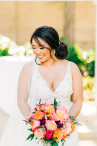 Classic Bride in Plunging V Neckline Lace Wedding Dress Holding Vibrant Colorful Pink, Orange Roses and Greenery Floral Bouquet | Tampa Bay Wedding Florist Monarch Events and Design