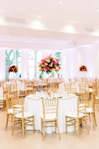 Elegant Wedding Reception Decor, Round Tables with White Table Linens, Gold Chiavari Chairs, Tall Gold Stand with Lush Vibrant Colorful Pink, Orange and Greenery Floral Centerpiece | Wedding Venue Tampa Garden Club | Wedding Rentals Kate Ryan Event Rentals | Wedding Florist Monarch Events and Design