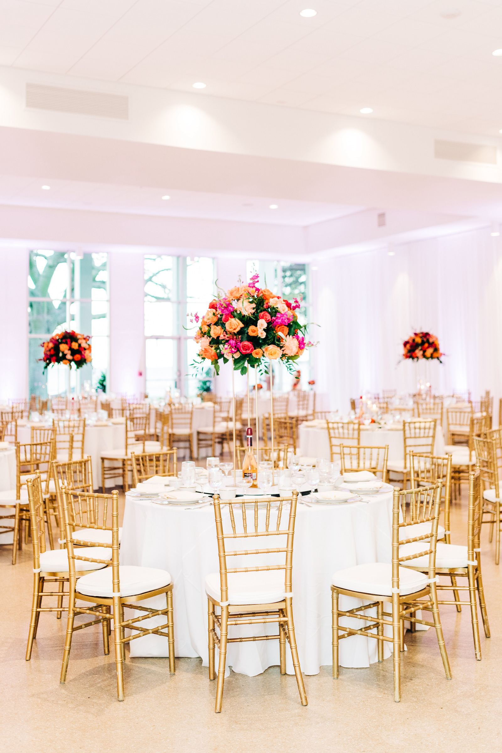 Elegant Wedding Reception Decor, Round Tables with White Table Linens, Gold Chiavari Chairs, Tall Gold Stand with Lush Vibrant Colorful Pink, Orange and Greenery Floral Centerpiece | Wedding Venue Tampa Garden Club | Wedding Rentals Kate Ryan Event Rentals | Wedding Florist Monarch Events and Design