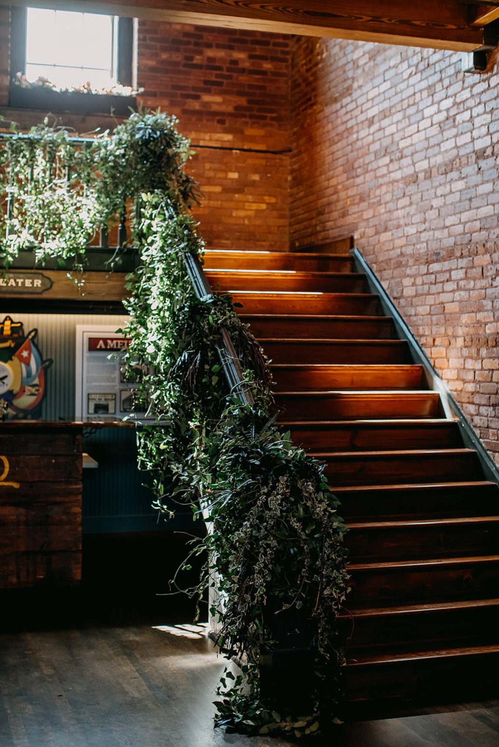 Vintage Inspired Tampa Bay Wedding Venue and Decor, Industrial Exposed Brick with Staircase decorated with Cascading Greenery, Ivy and Vines Wrapped Around Staircase | Unique Florida Wedding Venue J.C. Newman Cigar Co. in Ybor City