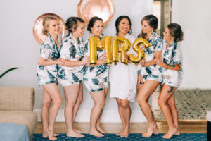 Tampa Bay Bride Holding Gold Foil Mrs Balloon with Bridesmaids in Tropical Matching Pajamas