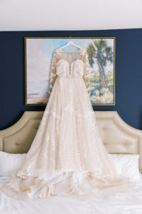 Romantic Adam Zohar A-Line Wedding Dress Hanging, Unique Beaded Pattern with Illusion Neckline and Lace Sleeve Detailing | Florida Wedding and Bridal Boutique Isabel O'Neil Bridal Collection