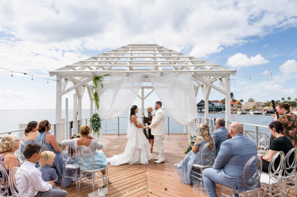 Waterfront Wedding Ceremony with Overwater Pier and White Pergola with Draping and Greenery | Tampa Wedding Venue The Godfrey