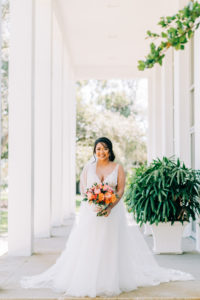 Classic Bride in Plunging V Neckline Lace Strap and Tulle A-Line Skirt Wedding Dress Holding Vibrant Colorful Pink and Orange Floral Bouquet | Tampa Bay Wedding Florist Monarch Events and Design | Wedding Venue Tampa Garden Club