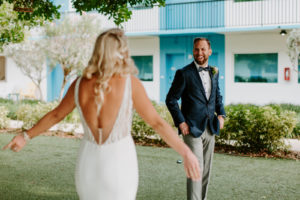 Tampa Bay Bride and Groom in Emerald Green Tuxedo Jacket and Bowtie First Look Photo | St. Pete Beach Wedding Venue Postcard Inn on the Beach