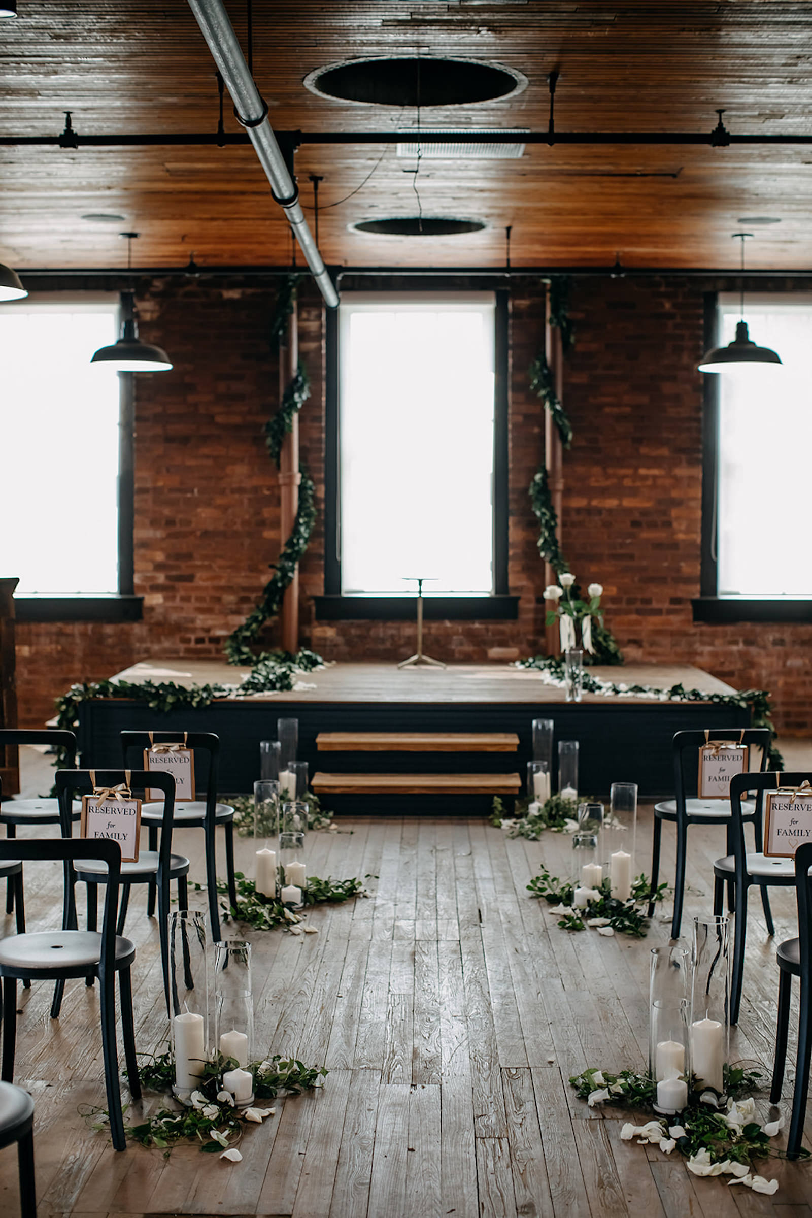 Vintage Inspired Tampa Bay Wedding Ceremony Decor, Simplisitic Brick Exposed Industrial venue, Metal Black Chairs, decorated with Candles, White Rose Petals, and Greenery, Ivy and Vines Wrapped Around Staircase | Unique Florida Wedding Venue J.C. Newman Cigar Co. in Ybor City