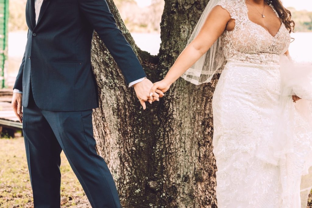Romantic Bride Wearing Lace Cap Sleeve Nude Bodice and White Skirt Wedding Dress and Groom Holding Hands First Touch/Look Outside Lake | Tampa Bay Wedding Photographer Bonnie Newman Creative | Wedding Dress Shop Truly Forever Bridal | Odessa Wedding Venue Barn at Crescent Lake