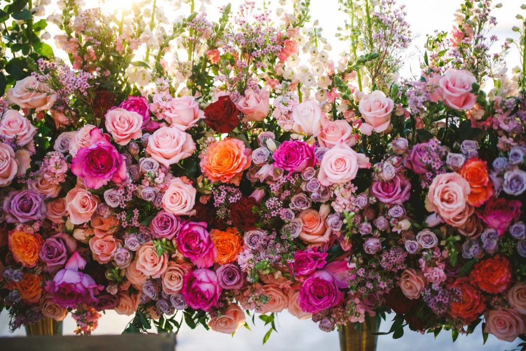 Wedding Ceremony Floral Arrangements featuring Colorful Blush Pink, Fuchsia, Purple and Orange Roses with Candles | Luxury Floral Wedding Arrangements Tailored Twig