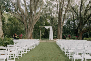 Outdoor Garden Wedding Ceremony, Wooden Rectangular Arch with White Drapery, White Folding Chairs | Tampa Bay Wedding Photographer Amber McWhorter Photography | Wedding Venue The Secret Garden at Paradise Spring