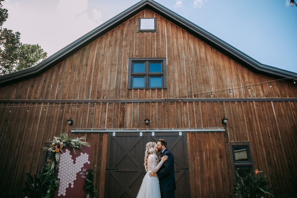 Rustic Bride and Groom Kissing Outside Barn | Tampa Wedding Venue Mision Lago Estate | Mision Lago Ranch