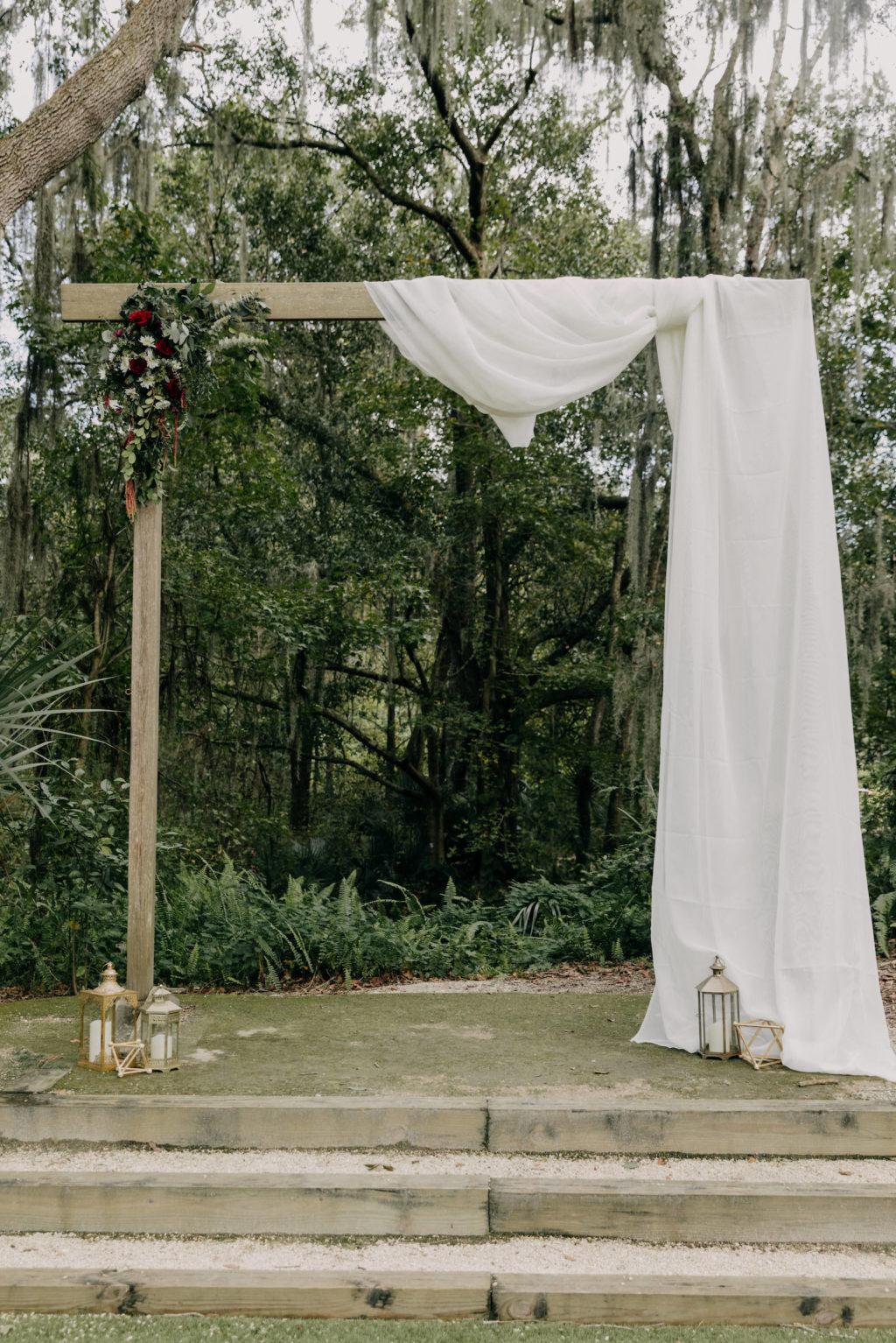 Outdoor Garden Wedding Ceremony, Wooden Rectangular Arch with White Drapery, White Folding Chairs | Tampa Bay Wedding Photographer Amber McWhorter Photography | Wedding Venue Paradise Spring
