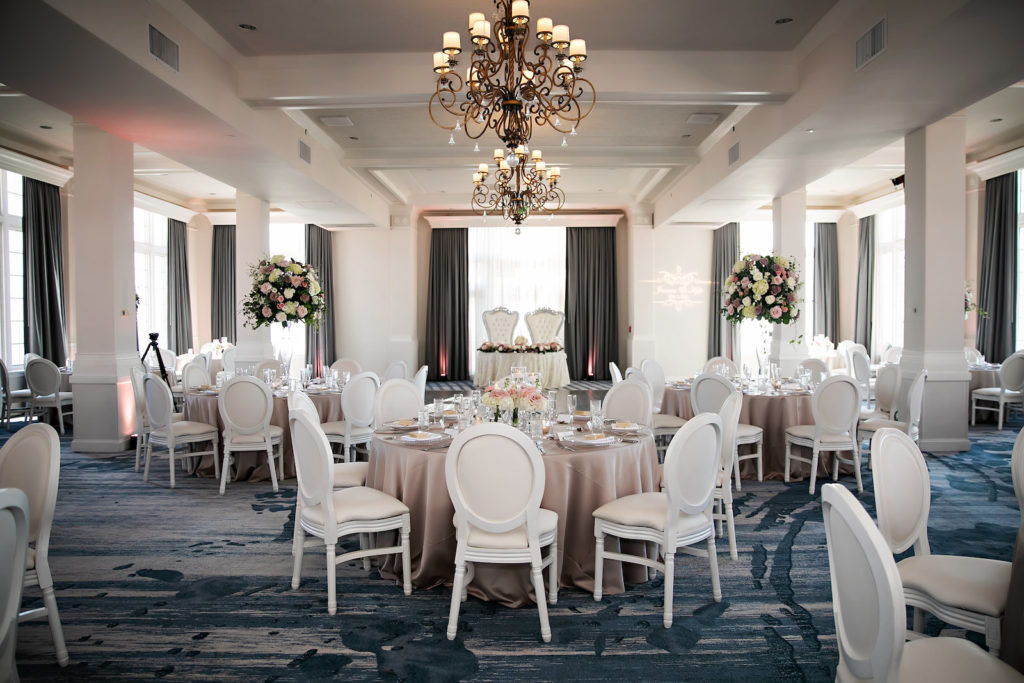 Vintage Inspired Ballroom Wedding Reception, Round Tables with Champagne Blush Linens and Lace Overlay, Modern Round Chairs, Tall Floral Centerpieces with Pink, Purple, Ivory, White Flowers with Greenery, Sweetheart Table | Historic St. Pete Beach Wedding Venue The Don CeSar | Tampa Bay Wedding Photographer Limelight Photography | Kate Ryan Event Rentals | Iza's Flowers | Florida Wedding Planner Blue Skies Weddings and Events |
