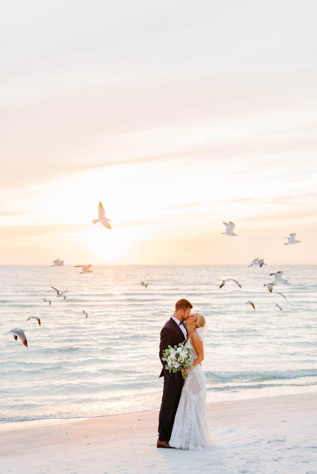 Romantic Bride and Groom Kissing on Florida Beach During Sunset with Seagull Birds Flying | Sarasota Wedding Venue The Resort at Longboat Key Club