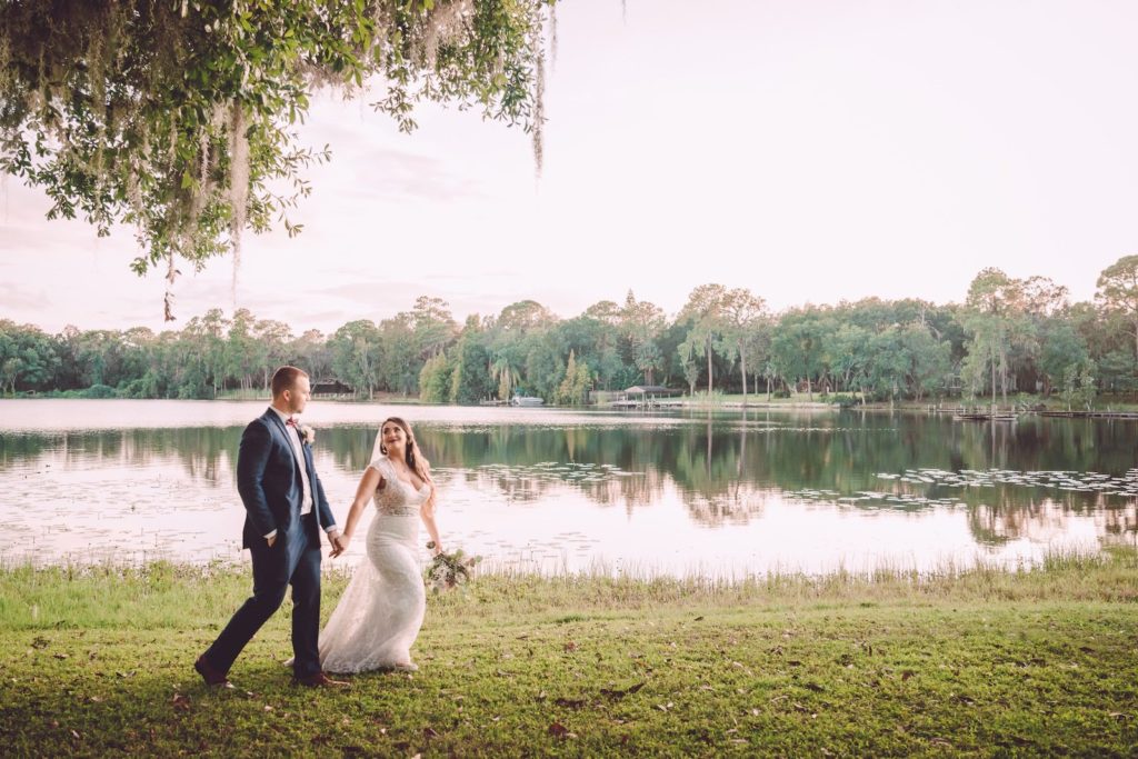 Romantic Shabby Chic Bride and Groom Walking Around Lake | Tampa Bay Wedding Photographer Bonnie Newman Creative | Wedding Venue Barn at Crescent Lake | Wedding Dress Shop Truly Forever Bridal