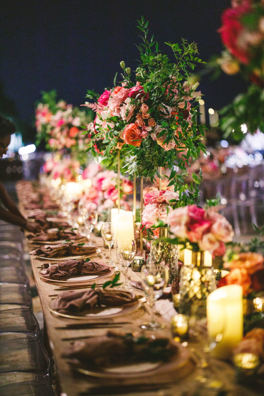 Luxury Elegant Tampa Wedding Reception with Long Feasting Tables featuring Colorful Blush Pink, Fuchsia and Orange Rose Centerpieces with Greenery and Candles